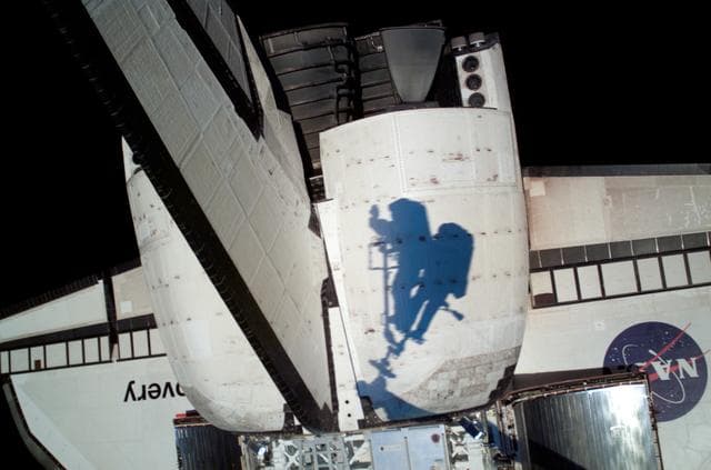 NASA image: EVA crewmembers shadows on the port OMS pod taken on EVA1 during STS-121 / Expedition 13 joint operations