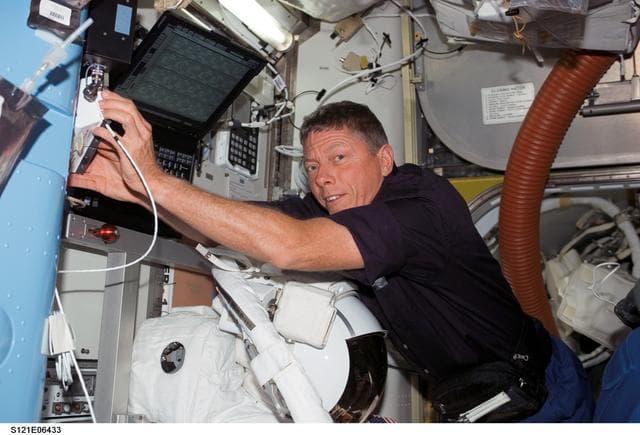 NASA image: Fossum stows tools in the A/L during STS-121 / Expedition 13 joint operations