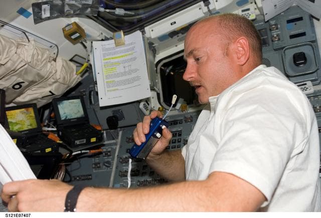 NASA image: Kelly talks on a mic as he provides support from the AFD during EVA3 on STS-121 / Expedition 13 joint operations