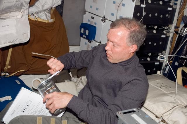 NASA image: Gorie manually activates a GAP using a small hand crank in the MDDK during Joint Operations