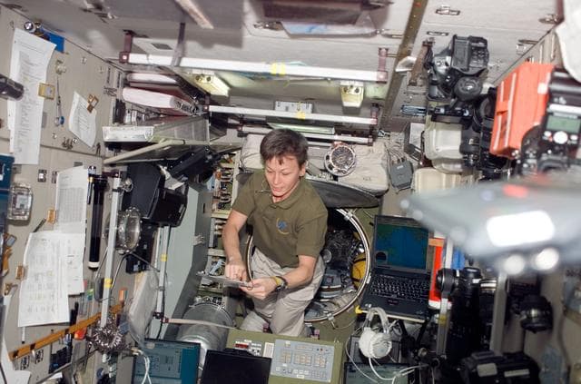 NASA image: Whitson looks over crew procedures in the SM during Joint Operations