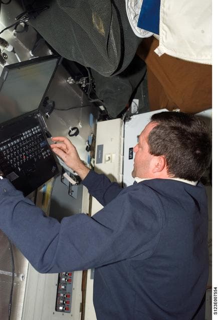 NASA image: STS-123 crewmember uses laptop computer in the FWD MDDK during Joint Operations