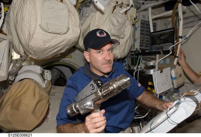Grunsfeld poses for a photo on the Shuttle Atlantis Middeck