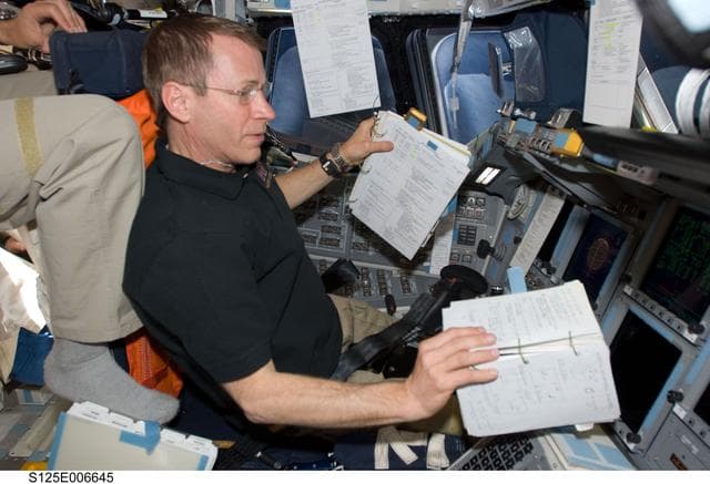 NASA image: STS-125 Crew working on the Shuttle Atlantis Flight Deck during HST Rendezvous