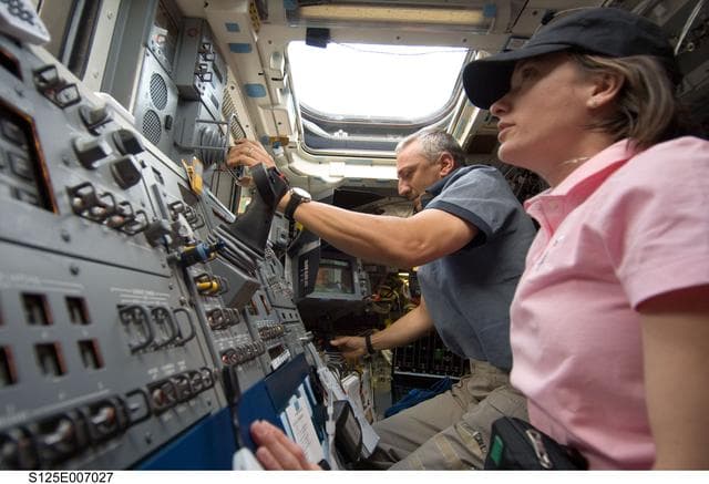 NASA image: STS-125 Crew working on the Shuttle Atlantis Flight Deck during HST Rendezvous/Berthing