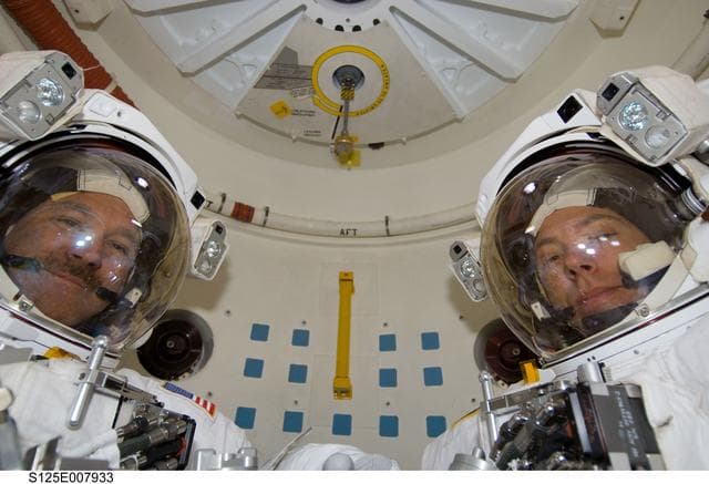 NASA image: STS-125 MS5 Feustel and MS3 Grunsfeld pose for a photo in the Airlock prior to EVA3