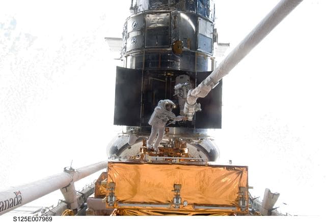 NASA image: STS-125 MS5 Feustel and MS3 Grunsfeld during EVA3