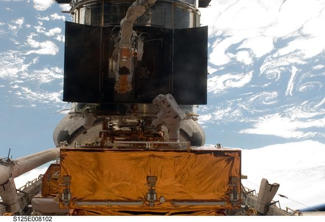 NASA image: STS-125 MS5 Feustel and MS3 Grunsfeld during EVA3