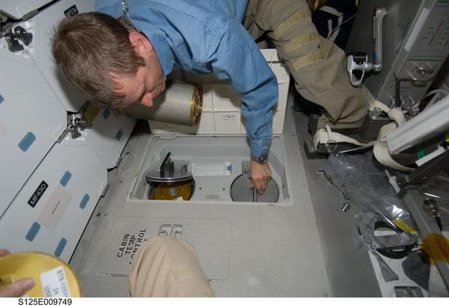 NASA image: STS-125 Pilot Johnson replaces LiOH Cannisters on the Shuttle Atlantis Middeck