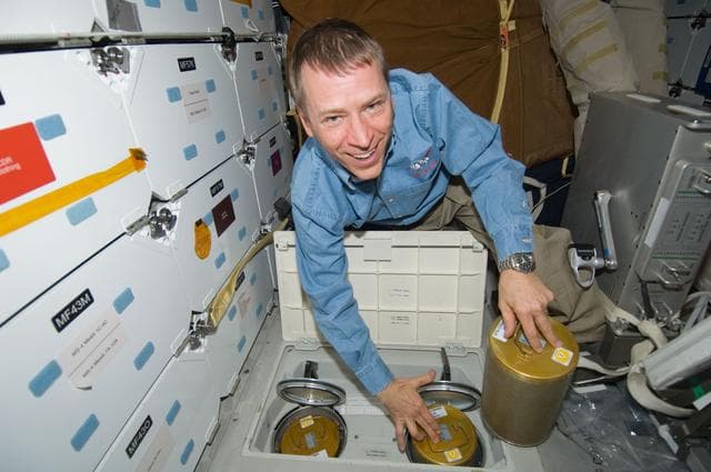 NASA image: STS-125 Pilot Johnson replaces LiOH Cannisters on the Shuttle Atlantis Middeck