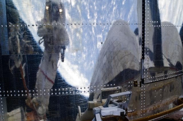 NASA image: An STS-125 Crew Member's image is reflected in the HST