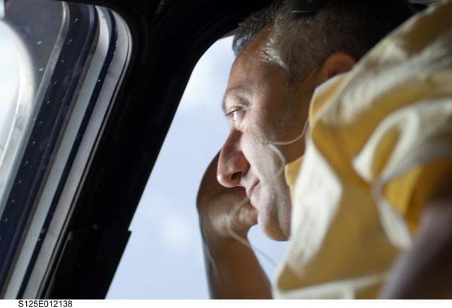 NASA image: View of MS4 Mike Massimino looks out a window on the Flight Deck