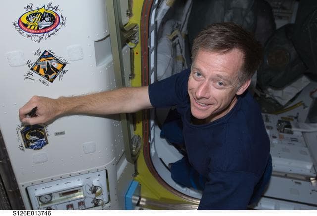 NASA image: Ferguson signs Mission Patch in A/L