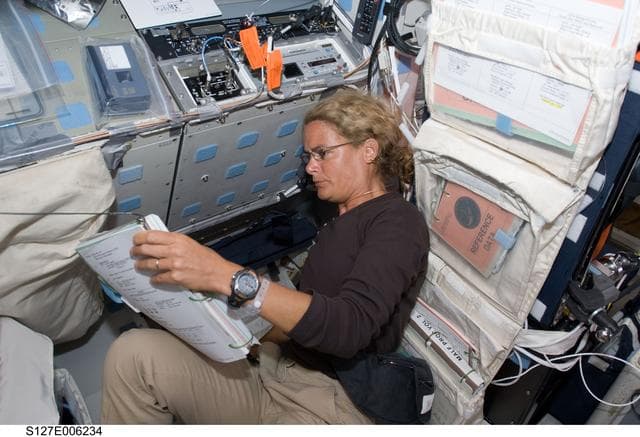 NASA image: Payette looks at procedures in the FD on the Space Shuttle Endeavour during the STS-127 Mission