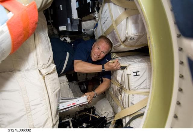 NASA image: Kopra looking at crew procedures on the Space Shuttle Endeavour during the STS-127 Mission
