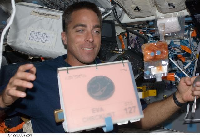 NASA image: Cassidy watches a checklist float in the FD during STS-127 / Expedition 20 Joint Operations