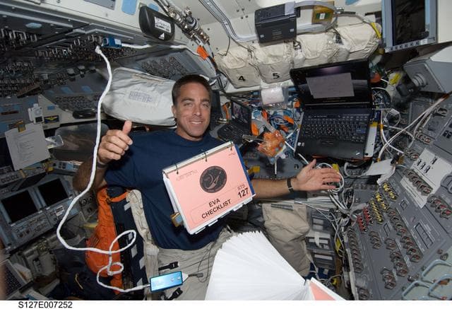 NASA image: Cassidy watches a checklist float in the FD during STS-127 / Expedition 20 Joint Operations