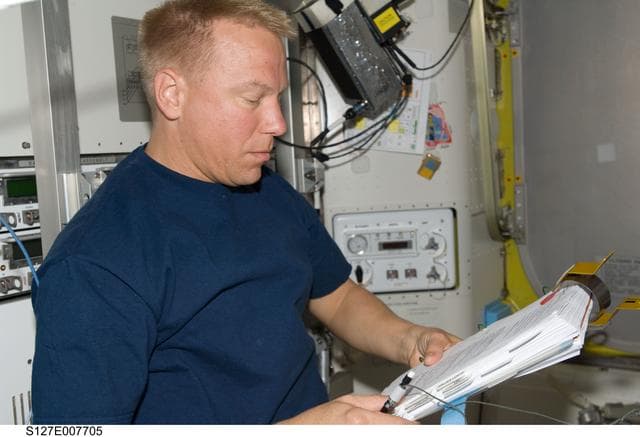 NASA image: Kopra looks at Crew Procedures in the A/L during EVA-3