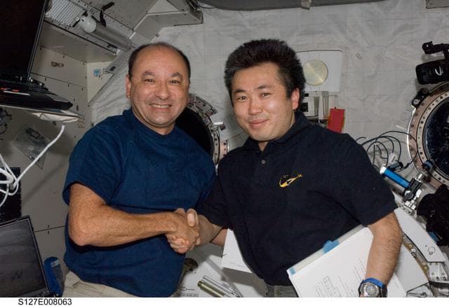 NASA image: Polansky and Wakata shake hands in the JPM during Joint Operations