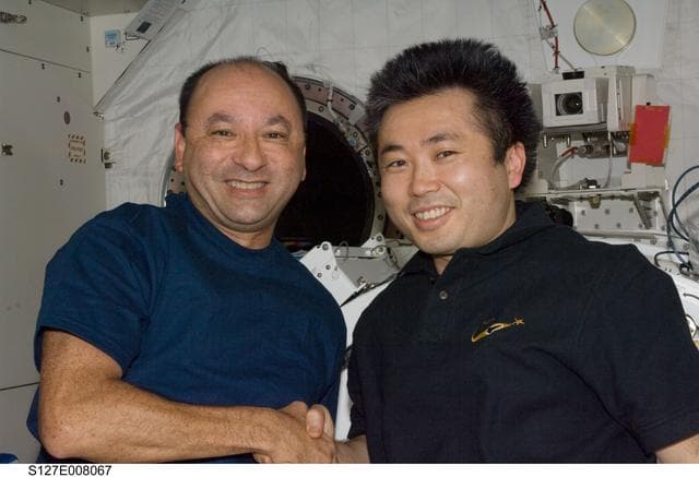 NASA image: Polansky and Wakata shake hands in the JPM during Joint Operations