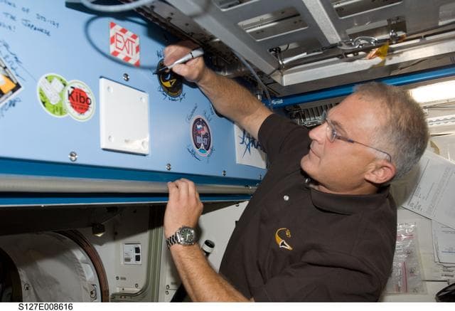 NASA image: Wolf signs mission decal in the JEM during Joint Operations