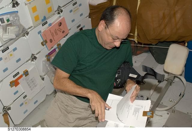 NASA image: Polansky looks at crews procedures in the FWD MDDK during Joint Operations