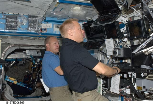 NASA image: Hurley and Kopra at the RMS in the U.S. Laboratory during Joint Operations