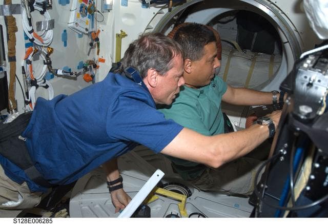 NASA image: Fuglesang and Hernandez at laptop on Middeck (MDDK) during STS-128