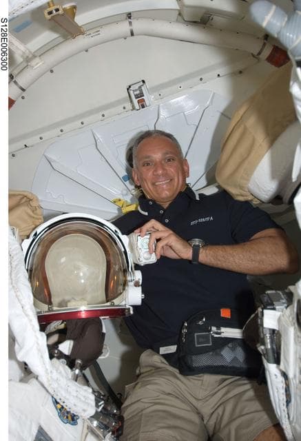 NASA image: Olivas in Shuttle Airlock with Extravehicular Mobility Units (EMU)s during STS-128