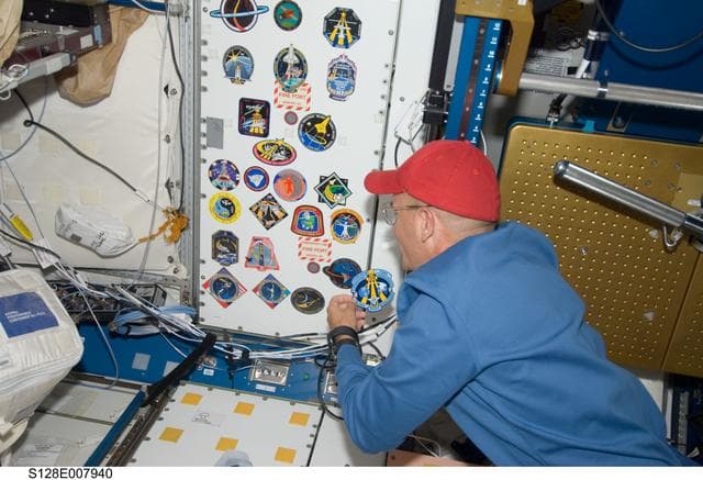 NASA image: Sturckow adds STS-128 crew patch to wall in Node 1 Unity