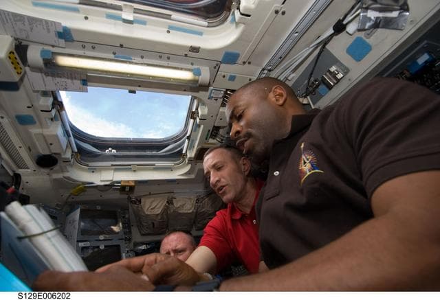 STS-129 Crew Members unberth the OBSS