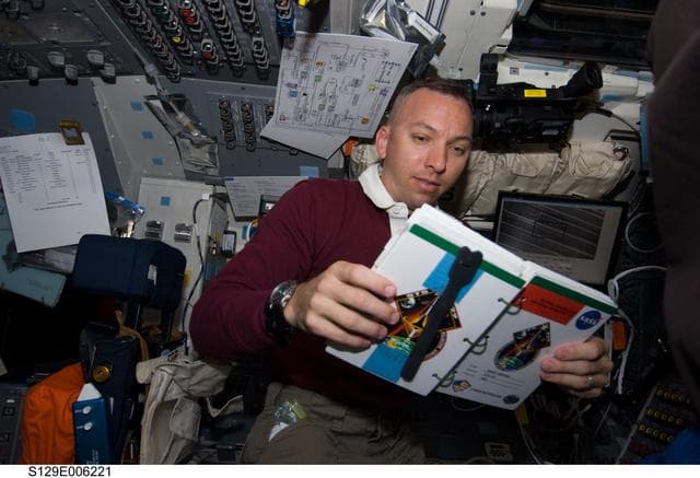 NASA image: STS-129 MS2 Bresnik reads his Crew Notebook on the FD