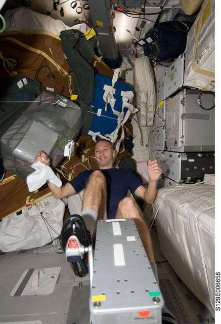 NASA image: STS-129 MS2 Bresnik exercises on the Middeck