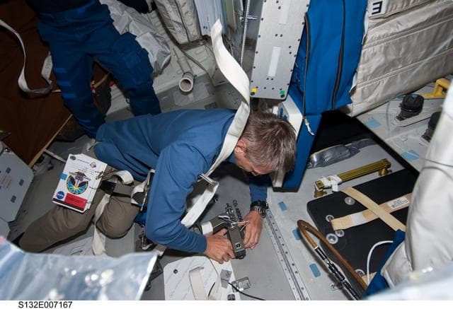 NASA image: Sellers works at the CO2 Absorber Panel Door in the MDDK during STS-132