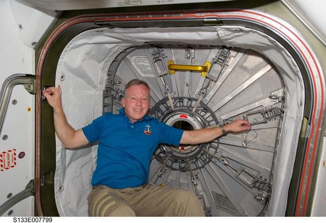 NASA image: Lindsey beside hatch to PMM (Permanent Multipurpose Module)