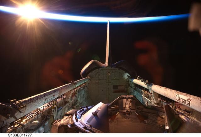 NASA image: Orbital sunrise over Discovery payload bay