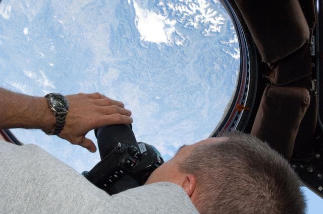 NASA image: STS-134 MS Feustel takes photos through a Cupola Window