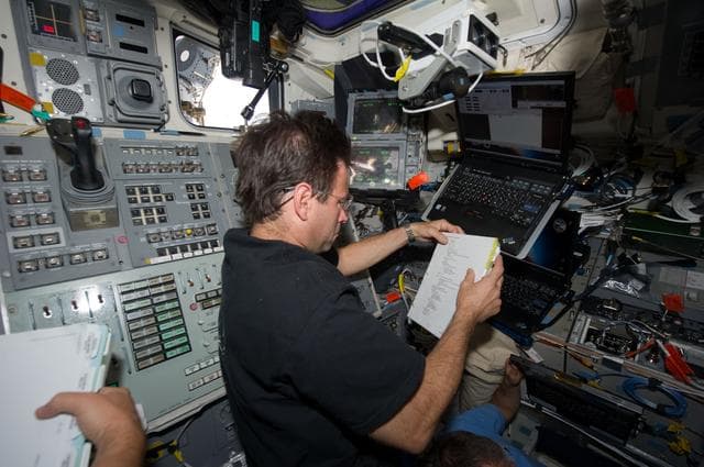 NASA image: STS-134 MS Chamitoff reads a Procedures Checklist