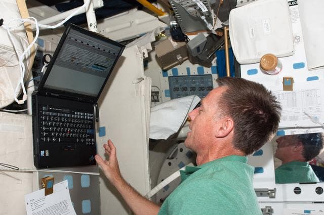 NASA image: Ferguson Uses a Computer on Atlantis Middeck