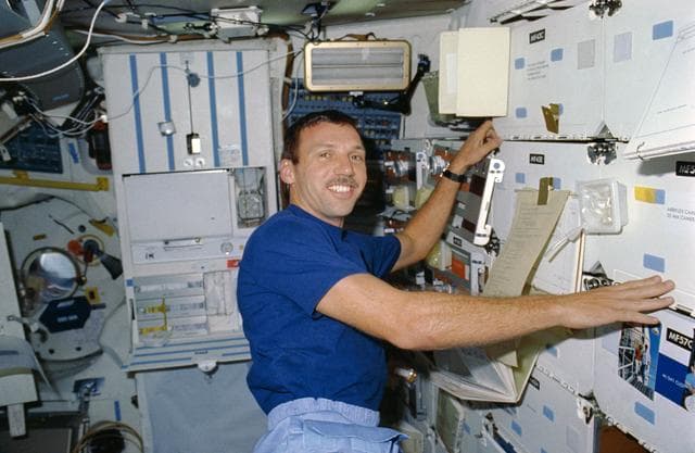 NASA image: STS-26 Mission Specialist (MS) Hilmers prepares meal on OV-103's middeck