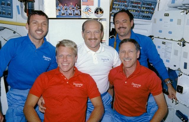 NASA image: STS-26 crewmembers pose for onboard portrait on middeck with 51L mementos