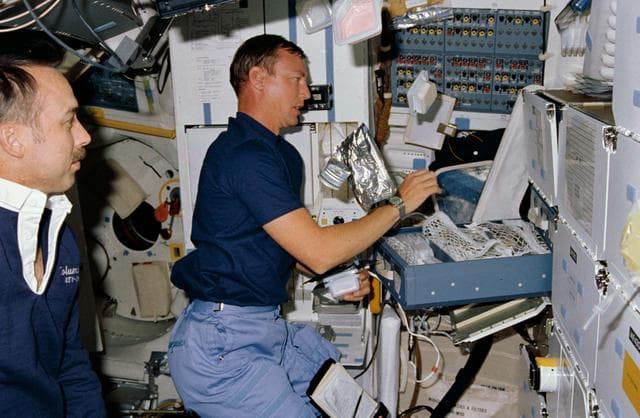 NASA image: STS-28 Columbia, OV-102, MS Brown juggles food containers on middeck