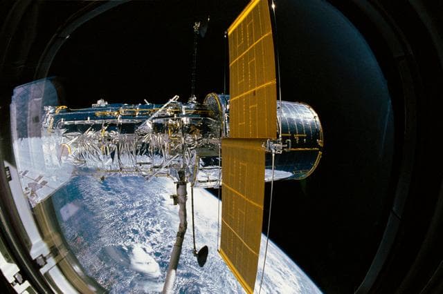 NASA image: STS-31 Hubble Space Telescope (HST) (SAs & HGAs deployed) is grappled by RMS