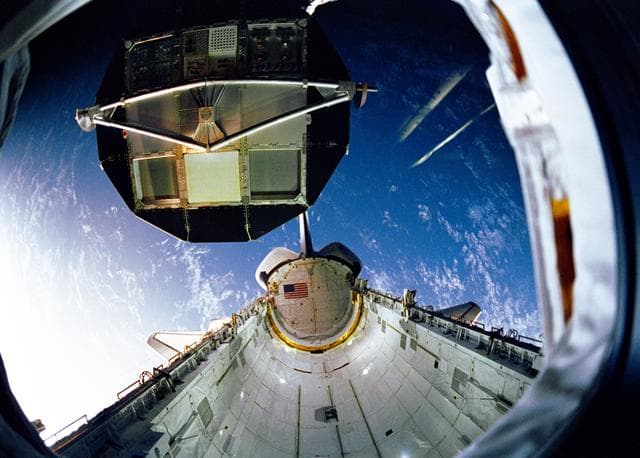 NASA image: During STS-32 retrieval, RMS lowers LDEF into OV-102's payload bay (PLB)