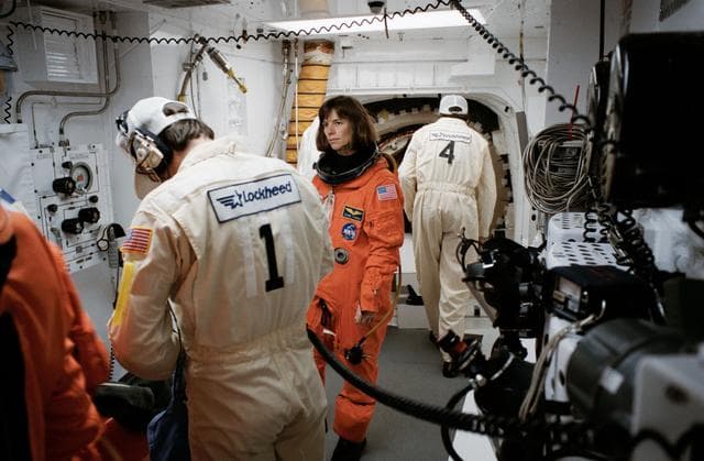 STS-32 MS Dunbar looks on as technicians prepare LES equipment in white room