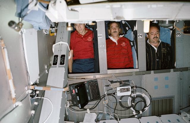 NASA image: STS-35 crewmembers in sleep station compartments on OV-102's middeck