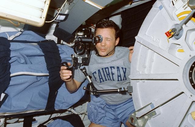NASA image: STS-36 Mission Specialist Thuot operates 16mm camera on OV-104's middeck