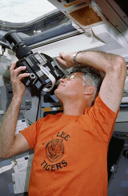 NASA image: STS-36 Mission Specialist Mullane uses 70mm HASSELBLAD camera on flight deck