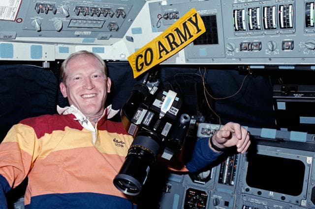 NASA image: STS-38 MS Gemar with camera and ARMY decal on OV-104's forward flight deck