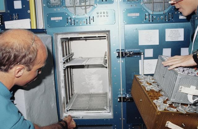 NASA image: STS-40 crewmembers remove specimens from SLS-1 Rack 9 Refrigerator / Freezer